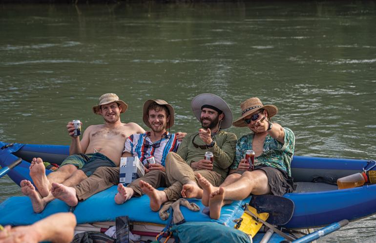 Guys hanging out drinking beer on raft