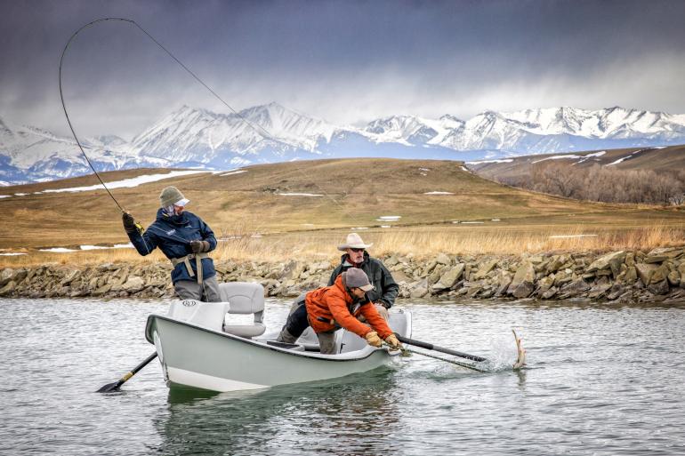 Netting a trout from a drift boat in winter