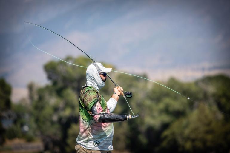 Fly fisherman with prosthetic arm casting