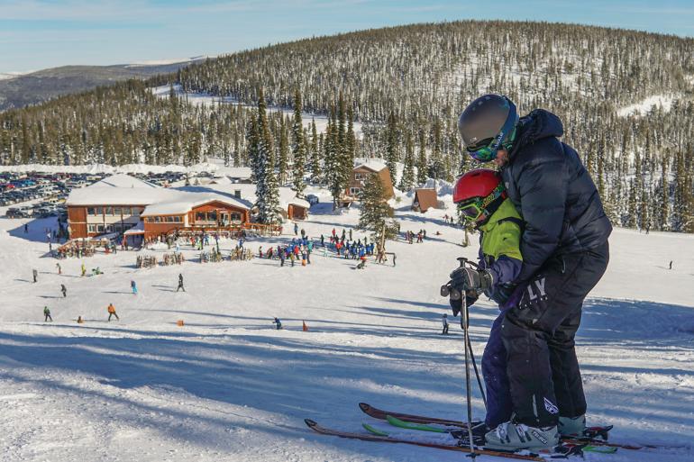 Parent teaching child to ski at Lost Trail