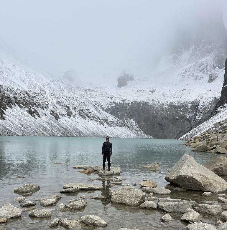 Omar Alveraz standing before a glacial lake in Patagonia