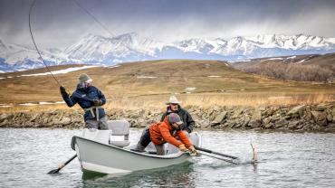 Netting a trout from a drift boat in winter