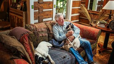 Thomas McGuane sitting with his dogs