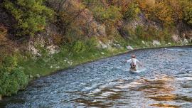 fisherman angler wading across river