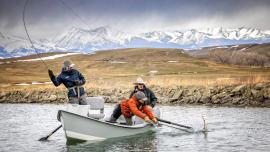 Netting a trout from a drift boat in winter