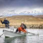 Netting a trout from a drift boat in winter